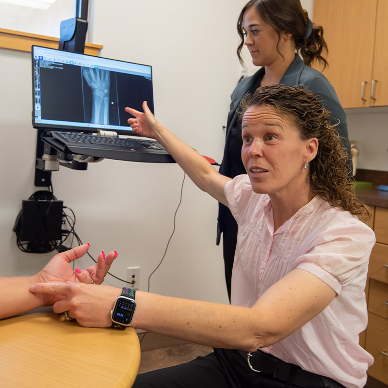 orthopedic specialist pointing at hand x ray